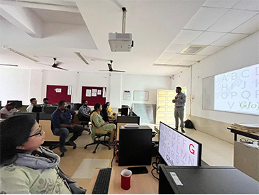 Two men in bicycle jerseys sitting outside at table having coffee